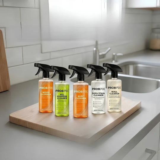 Five bottles of Probiotic cleaning products on a kitchen counter with a tiled wall and sink in the background.